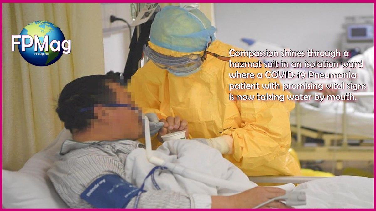Compassion shines through a hazmat suit in an isolation ward where a COVID-19 Pneumonia patient with promising vital signs is now taking water by mouth.